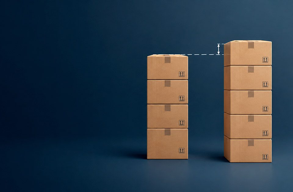 Dos pilas de cajas de distinta altura con una línea que marca la brecha, representando diferencias de inventario